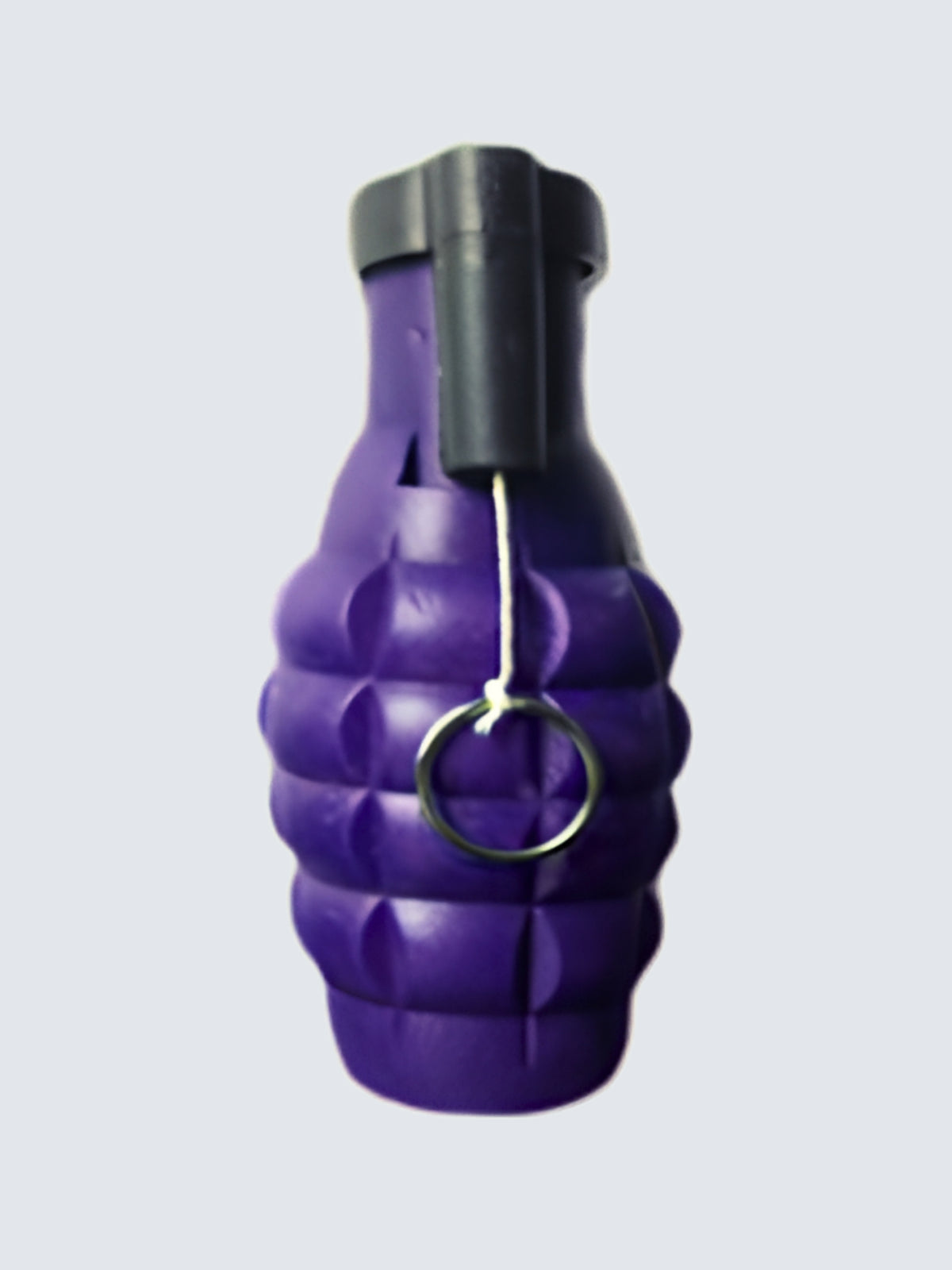 Purple grenade-shaped smoke novelty with a textured body, black top, and metal pull ring attached to a white string.